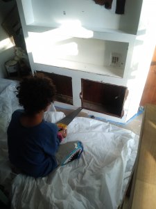 Boy using saw in camper renovation